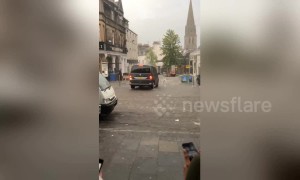 Bartenders chase after furniture being swept away by flooding in Scotland