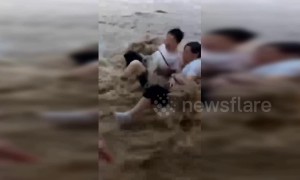 Pedestrians swept down road by flash flooding in China's Chongqing