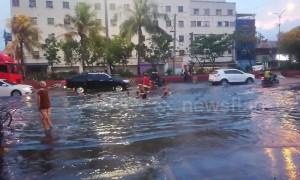 Children go 'bodyboarding' on flooded road in the Philippines following heavy downpours