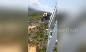 Vietnamese electrical workers do line repairs at terrifying heights