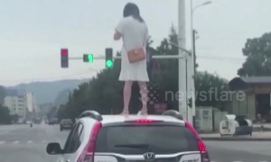 Angry woman climbs onto car roof on Chinese highway after 'arguing with husband'