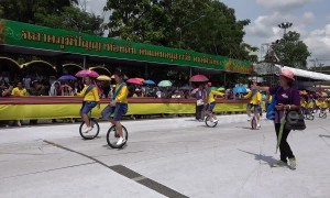 Adorable moment dozens of Thai schoolgirls dance on unicycles at Buddhist festival