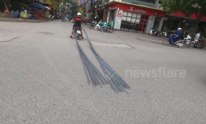 Motorbike stops traffic while dragging 6-metre long bundle of steel through crowded street