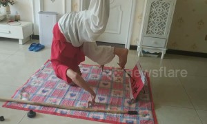 Elderly Chinese man headstands while practising calligraphy with his foot