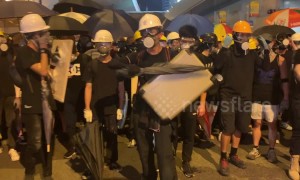 Hong Kong protesters create noise before a police push forces crowds back