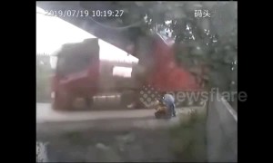 Truck trailer narrowly misses man after smashing into bridge in China