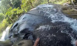 'Sticky' waterfall becomes Thai tourist attraction with people clambering barefooted over the rocks