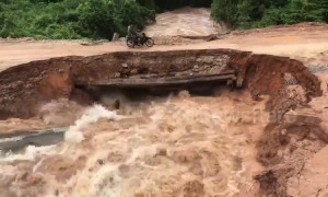 Shocking moment motorcyclists plunge into rapid floodwater after makeshift bridge collapses in Cambodia