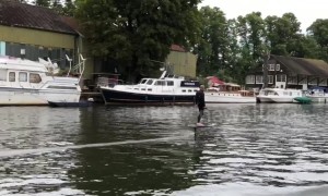 Man on a hover surfboard zooms along the River Thames