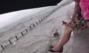 Chinese man escapes being swept out to sea after large wave knocks him off his feet