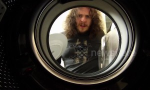 Man loads washing machine with dirty dishes