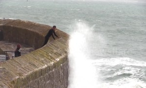 Huge waves crash over harbour wall in Cornwall drenching locals braving the rough seas