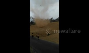 Fearless kids run into massive dust devil in Indonesia