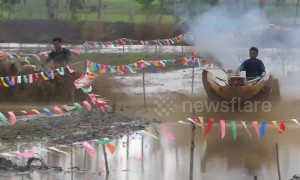 Thai farmers race tractors in paddy fields for rice planting festival