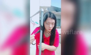 Chinese girl uses a hot outdoor water pipe to curl her hair