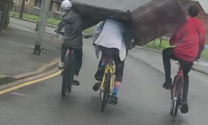 Squad of Cyclists Carry a Couch