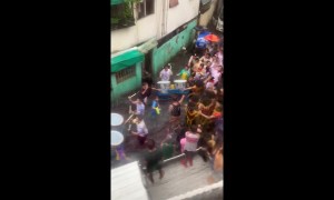 Carnival in Philippines crosses road flooded by Storm Bailu