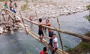 Villagers waiting six years for bridge to be finished make their own from bamboo