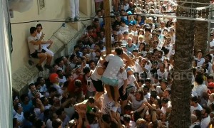 Residents in Spain battle to climb a pole during the infamous La Tomatina festival