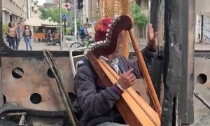 Musician Performs in Burned Out Bus