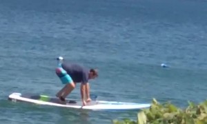 Man Struggles with Lakeside Paddleboard