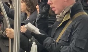 Person Climbs into Handlebars on Subway Train
