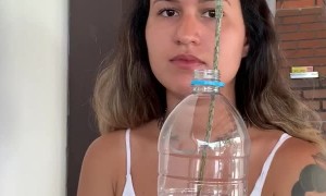 Woman Practices Magic Trick with an Apple and a Bottle