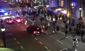 Police SUV runs through crowd crossing the street