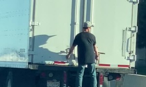 Man Hangs Onto Truck Traveling Along Highway