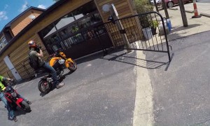 Rider Wheelies into Metal Fencing by Restaurant