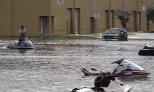 People ride jet skis through flooded Miami streets