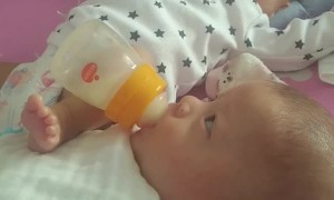 Baby Helping Feed Brother With Rocking Leg