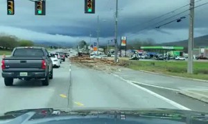Logging truck spills load all over highway, causes massive damage