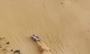 Full throttle truck drives up insanely steep sand dune