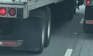 Guy Riding on Side of 18-Wheeler Holding Mirror