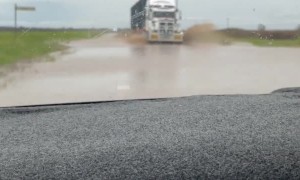 Truck Driving on Flooded Roads Covers Car