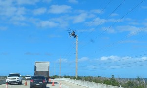 Linesman Balancing on Helicopter for Work