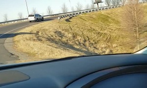 Female Driving at High Speeds with Guy on Hood of SUV