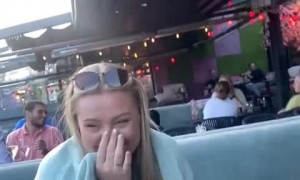 Young woman casually picks up seagull in restaurant