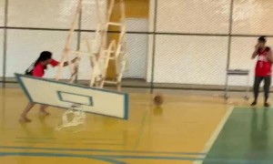 Friend Helps Complete a Dunk Breaking Basket