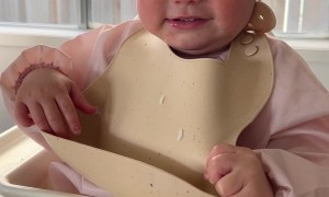 Baby Tries to Take Her Bib Off