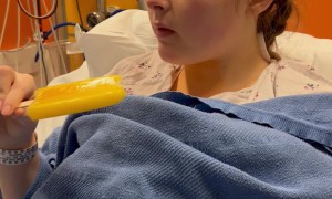 Girl Recovering From Surgery Takes a Bite Out of a Popsicle