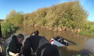 Police officers save woman stranded in her car from flooded ford