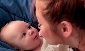 Mom preciously gives her baby loving kisses