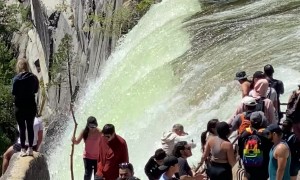 Yosemite Tourists Stand Near Waterfall Edge