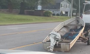 Precariously Placed Boat Falls Off Tire-less Trailer
