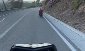 Motorcycle Follows Wheelchair Down Hill