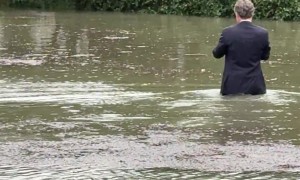 Fully Suited Man Wades Through Floodwater