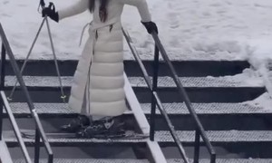 Woman Descends Stairs in Skis