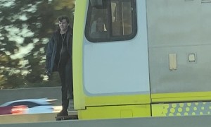 Train Hopping Fellow Waves to Traffic